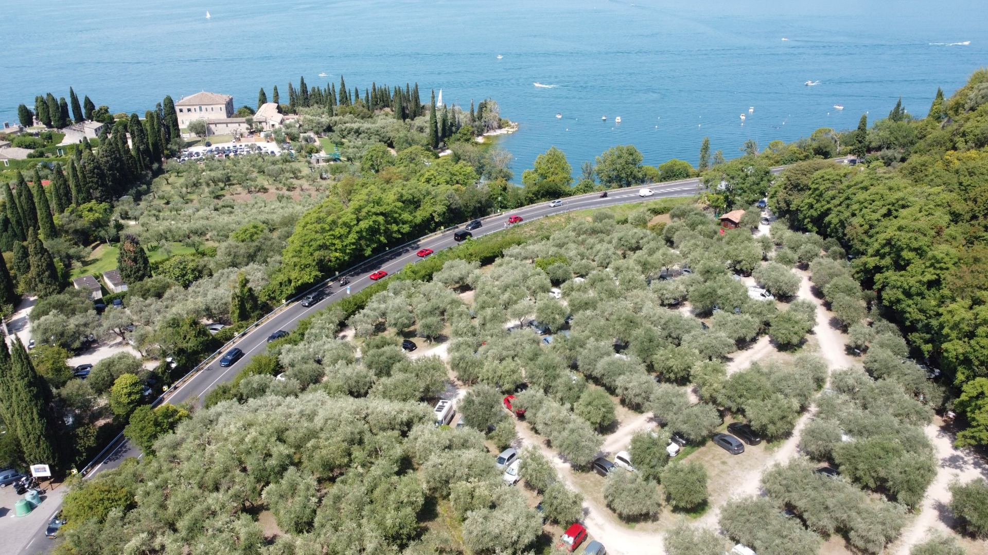Veduta aerea di Punta San Vigilio con cipressi, ulivi e il Lago di Garda